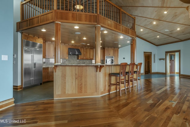 141 Janelle Dr, Bay Saint Louis, MS 39520 - kitchen with appliances with stainless steel finishes, high vaulted ceiling, under cabinet range hood, dark wood-style flooring, and tasteful backsplash