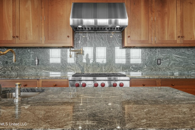 141 Janelle Dr, Bay Saint Louis, MS 39520 - kitchen featuring wall chimney exhaust hood, stove, a sink, and dark stone counters