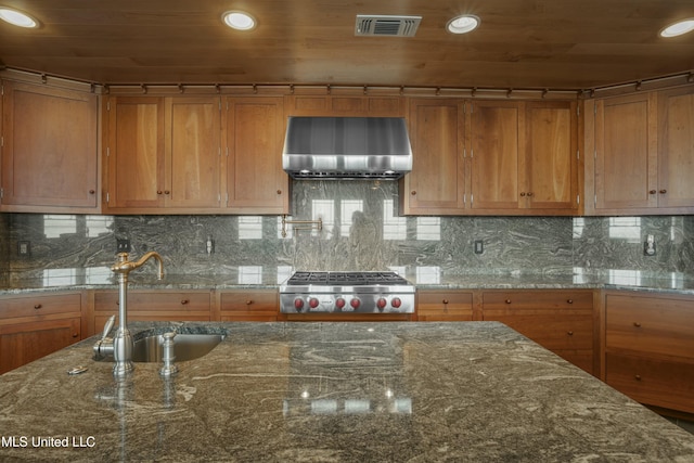 141 Janelle Dr, Bay Saint Louis, MS 39520 - kitchen featuring a sink, wall chimney range hood, brown cabinets, rail lighting, and recessed lighting