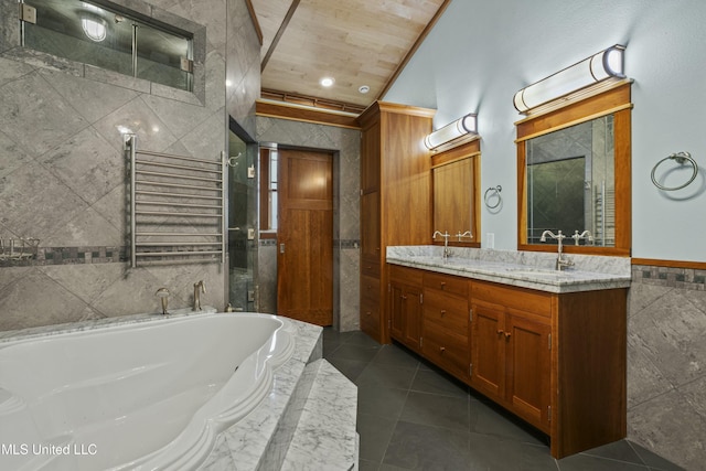 141 Janelle Dr, Bay Saint Louis, MS 39520 - bathroom featuring tile walls, double vanity, a bath, radiator heating unit, and tile patterned floors
