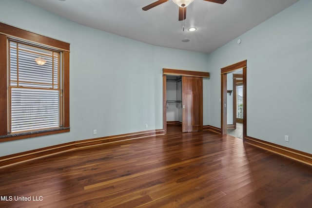 141 Janelle Dr, Bay Saint Louis, MS 39520 - unfurnished bedroom with hardwood / wood-style flooring, a closet, baseboards, a ceiling fan, and a walk in closet