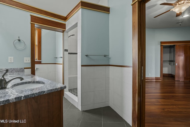 141 Janelle Dr, Bay Saint Louis, MS 39520 - bathroom with ceiling fan, a stall shower, tile walls, vanity, and a wainscoted wall