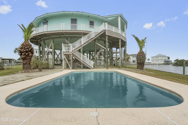 141 Janelle Dr, Bay Saint Louis, MS 39520 - back of house featuring stairs, an outdoor pool, a water view, and fence
