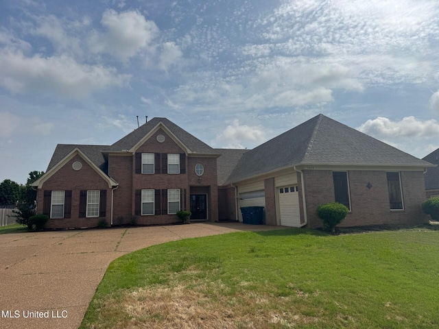 7428 Wallingford Dr, Olive Branch, MS 38654 - colonial house with brick siding, a front yard, an attached garage, driveway, and roof with shingles