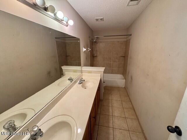 7428 Wallingford Dr, Olive Branch, MS 38654 - bathroom featuring double vanity, tile patterned flooring, a textured ceiling, and shower / tub combination