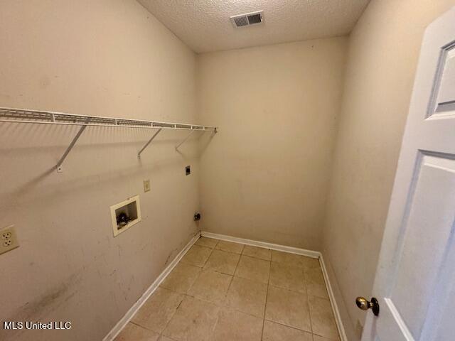 7428 Wallingford Dr, Olive Branch, MS 38654 - laundry room featuring hookup for an electric dryer, hookup for a washing machine, light tile patterned floors, a textured ceiling, and baseboards
