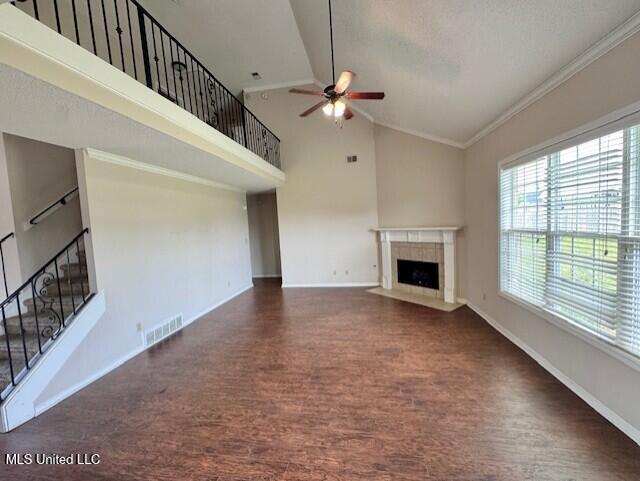 7428 Wallingford Dr, Olive Branch, MS 38654 - unfurnished living room with wood finished floors, a ceiling fan, baseboards, a tile fireplace, and ornamental molding
