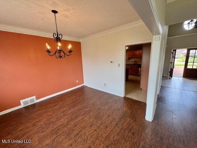 7428 Wallingford Dr, Olive Branch, MS 38654 - unfurnished dining area featuring a chandelier, wood finished floors, ornamental molding, and baseboards