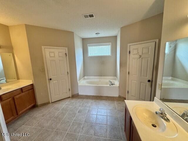 7428 Wallingford Dr, Olive Branch, MS 38654 - bathroom with a bath, two vanities, tile patterned floors, and baseboards