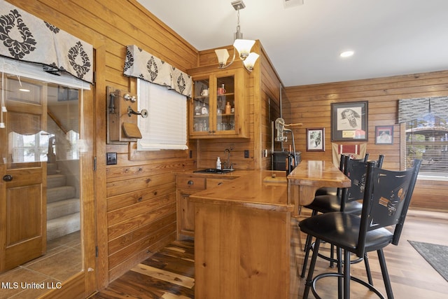 130 Pine Lake Cv, Flora, MS 39071 - bar featuring stairs, wood finished floors, indoor wet bar, wooden walls, and a sink