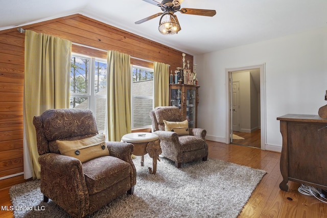 130 Pine Lake Cv, Flora, MS 39071 - sitting room featuring ceiling fan, vaulted ceiling, wood walls, wood finished floors, and baseboards
