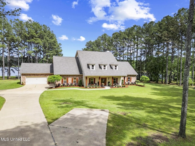 130 Pine Lake Cv, Flora, MS 39071 - view of front of property featuring a garage, a front yard, roof with shingles, brick siding, and concrete driveway