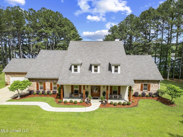 130 Pine Lake Cv, Flora, MS 39071 - cape cod house featuring a porch, concrete driveway, a chimney, and a front yard
