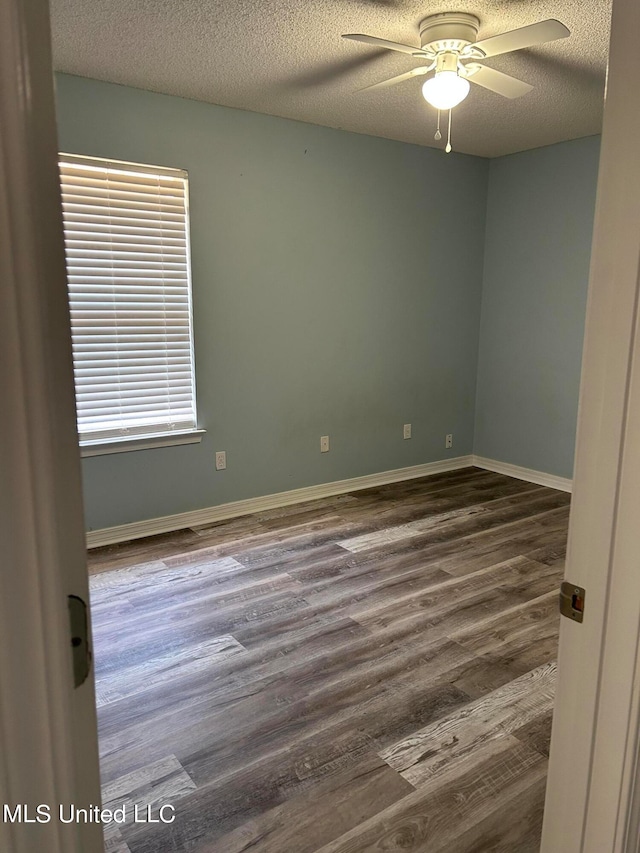 unfurnished room featuring ceiling fan, a textured ceiling, and dark hardwood / wood-style flooring