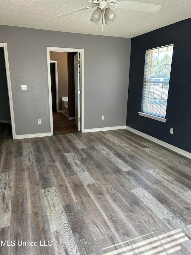 spare room featuring dark hardwood / wood-style floors, a textured ceiling, and ceiling fan