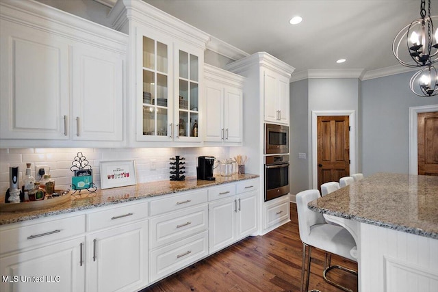 102 Hampton Chase, Madison, MS 39110 - kitchen featuring appliances with stainless steel finishes, a breakfast bar area, decorative backsplash, white cabinets, and crown molding