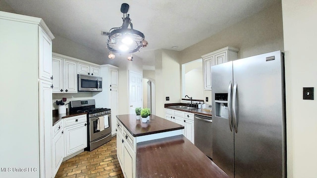 2252 Beach Dr Unit 701, Gulfport, MS 39507 - kitchen with appliances with stainless steel finishes, dark countertops, arched walkways, brick floors, and a center island