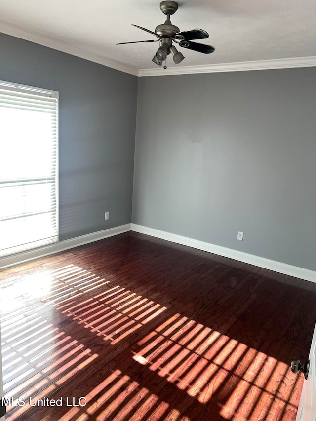 spare room with dark wood-type flooring, ceiling fan, and crown molding