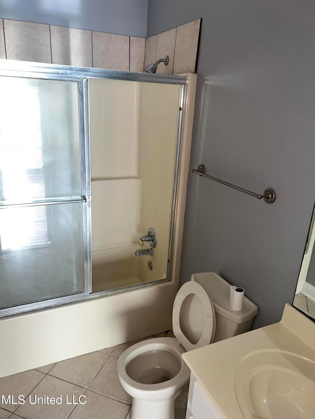 full bathroom with toilet, vanity, bath / shower combo with glass door, and tile patterned flooring