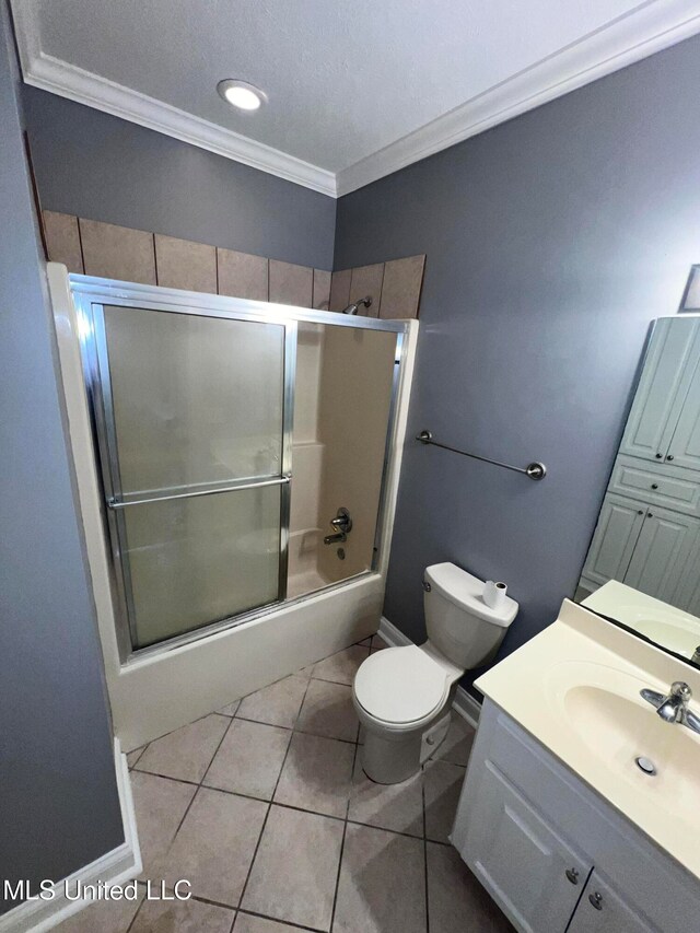 full bathroom featuring shower / bath combination with glass door, tile patterned floors, ornamental molding, vanity, and toilet