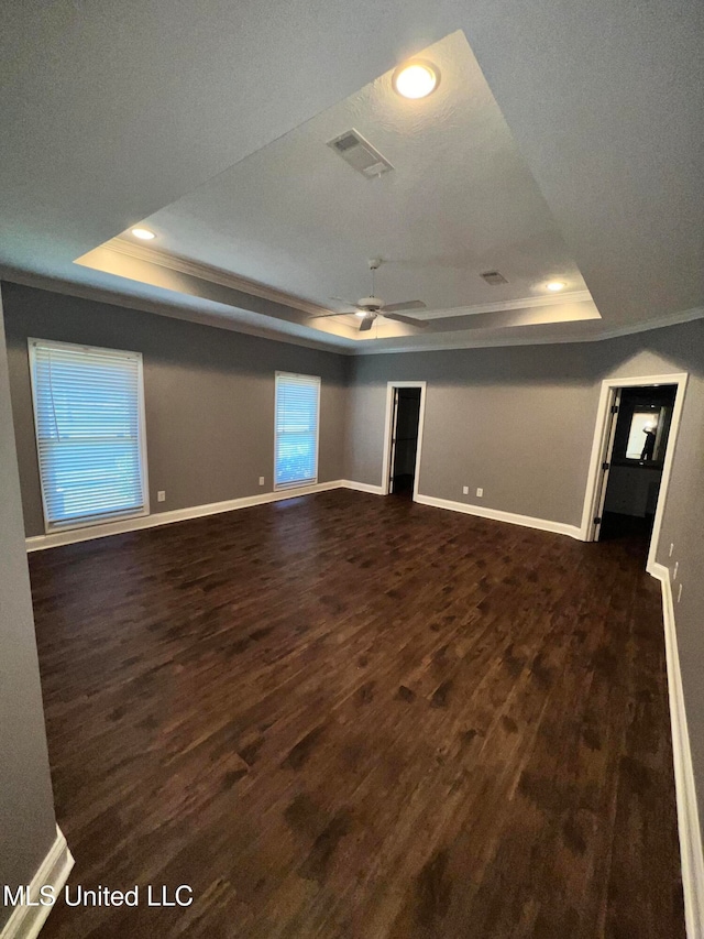 unfurnished room featuring a textured ceiling, dark hardwood / wood-style floors, crown molding, a raised ceiling, and ceiling fan