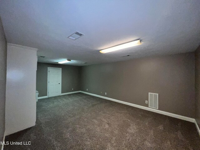 basement featuring dark carpet