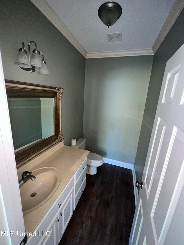 bathroom featuring ornamental molding, vanity, hardwood / wood-style flooring, and toilet