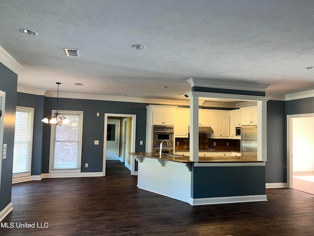 kitchen featuring stainless steel appliances, pendant lighting, a chandelier, ornamental molding, and white cabinetry