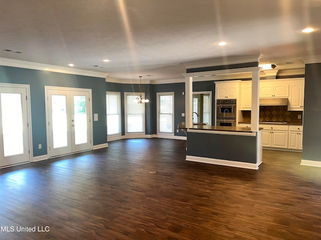 unfurnished living room featuring french doors, crown molding, dark hardwood / wood-style flooring, sink, and a chandelier