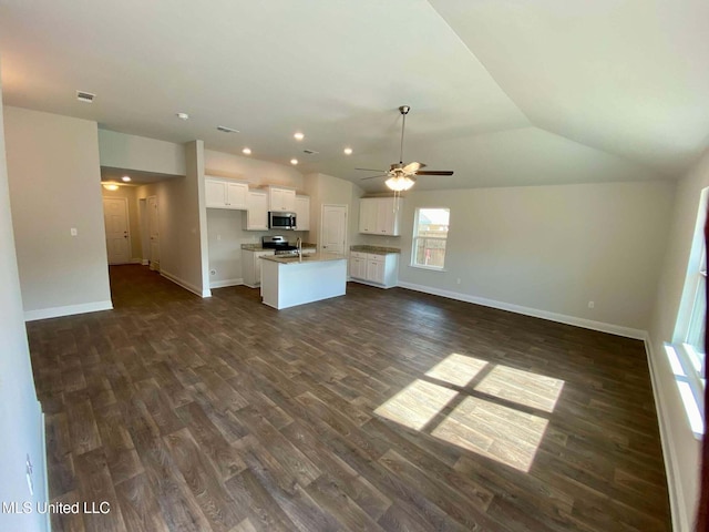 kitchen with white cabinetry, lofted ceiling, an island with sink, dark hardwood / wood-style flooring, and stainless steel appliances