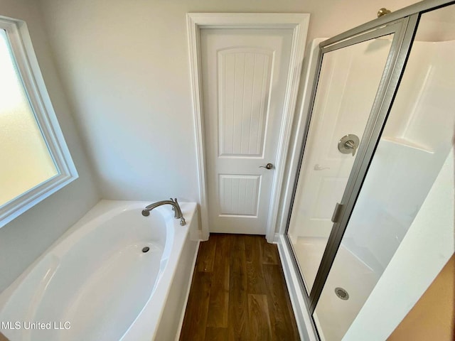 bathroom featuring wood-type flooring and shower with separate bathtub