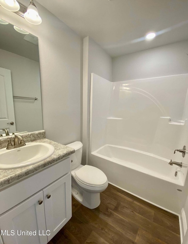 full bathroom with vanity, hardwood / wood-style flooring, bathing tub / shower combination, and toilet