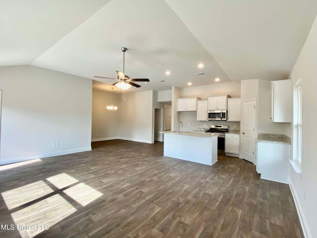 kitchen with lofted ceiling, sink, appliances with stainless steel finishes, an island with sink, and white cabinets