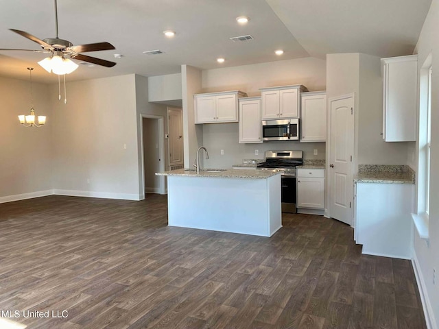 kitchen with appliances with stainless steel finishes, sink, white cabinets, dark hardwood / wood-style flooring, and light stone counters