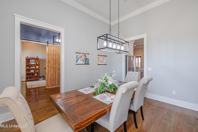 dining space with ornamental molding, dark wood-style flooring, baseboards, and a barn door