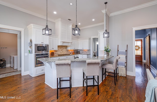 kitchen featuring appliances with stainless steel finishes, a breakfast bar, white cabinets, and dark wood-style floors