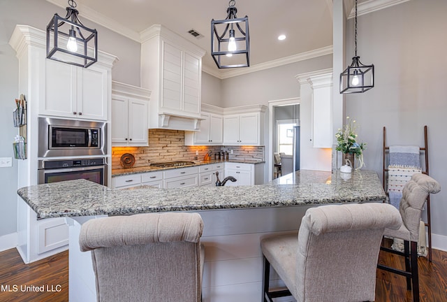 kitchen with crown molding, tasteful backsplash, visible vents, appliances with stainless steel finishes, and white cabinetry