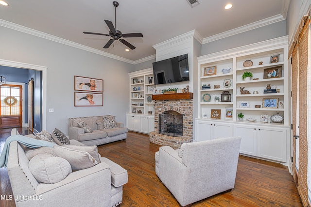 living room featuring dark wood-style floors, ceiling fan, a brick fireplace, and crown molding