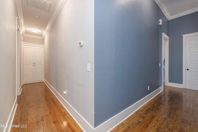 hallway featuring baseboards, crown molding, and wood finished floors