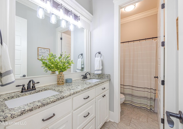 full bathroom featuring toilet, crown molding, double vanity, and a sink