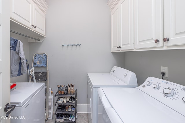 laundry room featuring cabinet space, independent washer and dryer, and baseboards