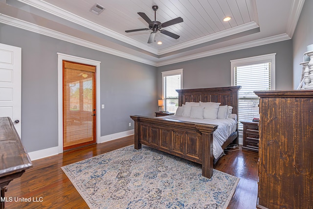 bedroom featuring visible vents, baseboards, a tray ceiling, dark wood finished floors, and crown molding