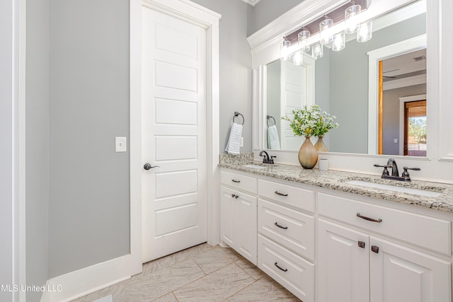 full bath featuring marble finish floor, double vanity, and a sink