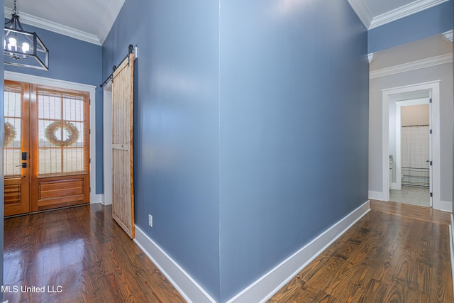 foyer entrance with baseboards, a barn door, wood finished floors, and crown molding