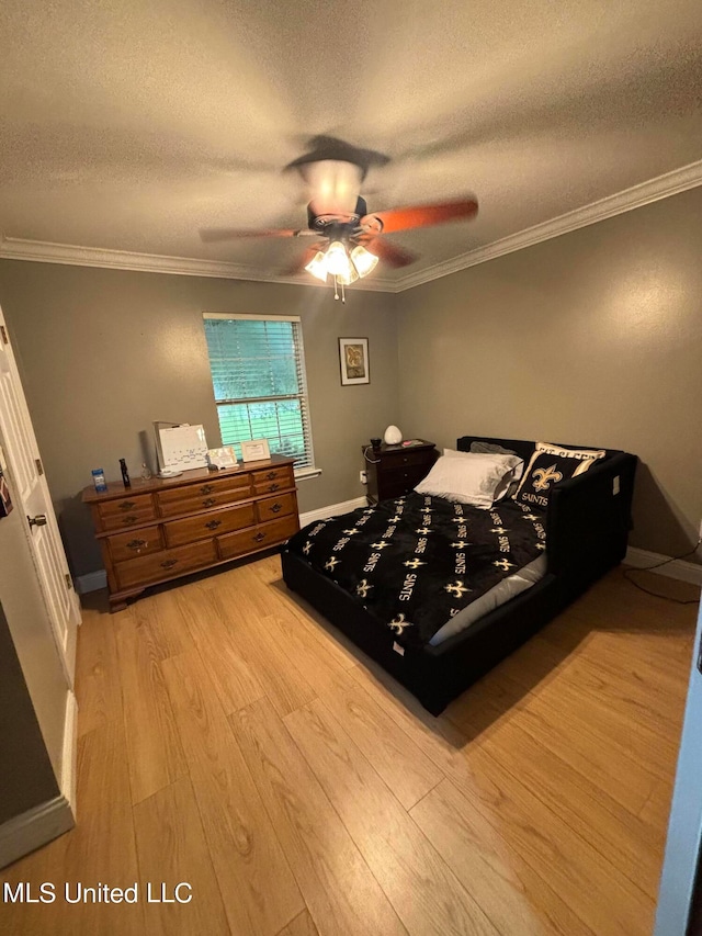 bedroom featuring ornamental molding, a textured ceiling, and wood finished floors