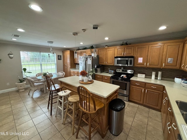 kitchen featuring backsplash, a breakfast bar, a center island, decorative light fixtures, and appliances with stainless steel finishes