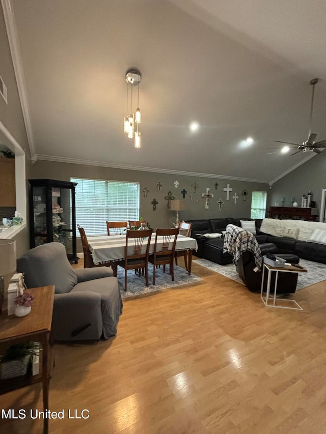 living room featuring wood finished floors, ornamental molding, and vaulted ceiling