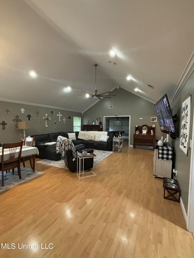 living area featuring light wood-style floors, ceiling fan, crown molding, and vaulted ceiling