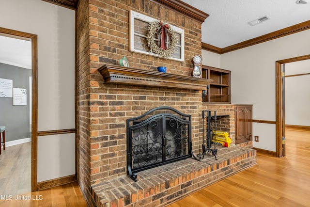 living room with ornamental molding, wood finished floors, baseboards, and a brick fireplace