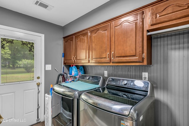 washroom with cabinet space and washer and clothes dryer